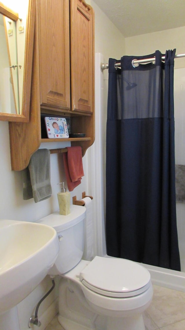 bathroom with tile patterned flooring, a shower with curtain, and toilet