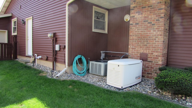 view of side of home with central AC and a yard