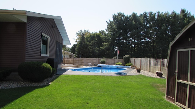 view of pool with a lawn and a storage shed