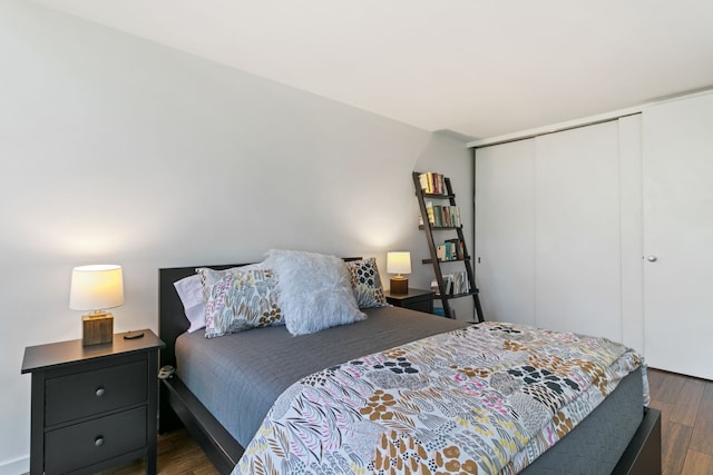 bedroom with dark wood-type flooring and a closet