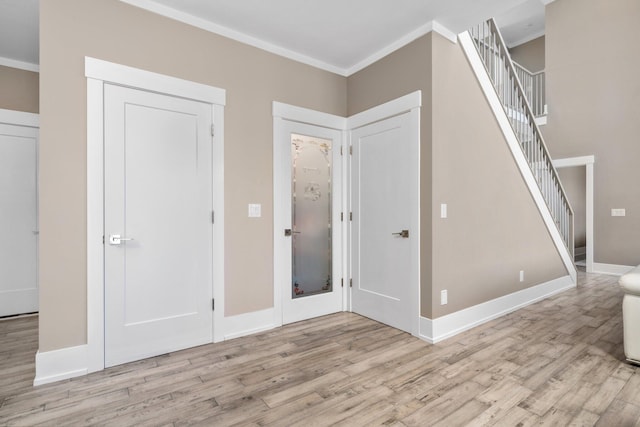 foyer featuring light wood-type flooring and ornamental molding