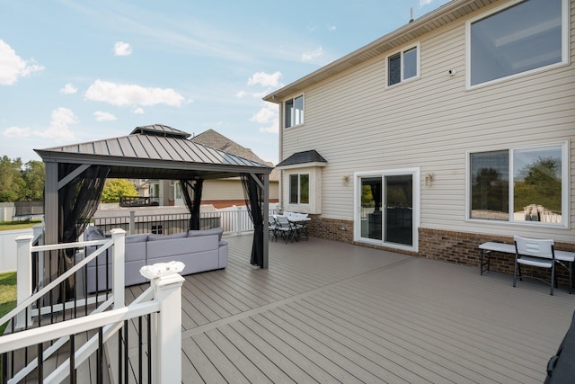 wooden terrace featuring a gazebo and an outdoor living space