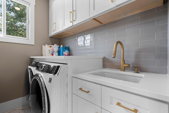 washroom featuring cabinets, independent washer and dryer, and sink