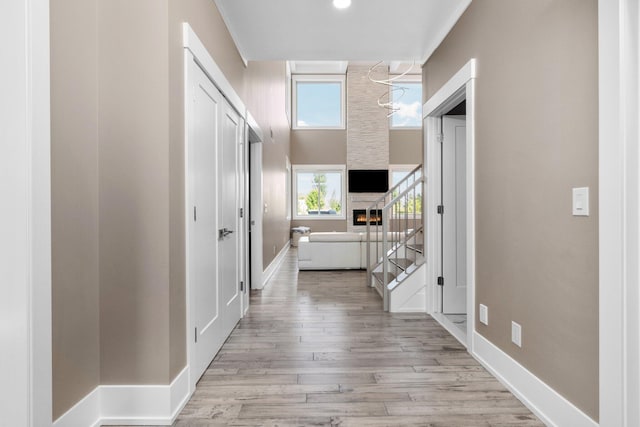 hall with light hardwood / wood-style flooring and a chandelier