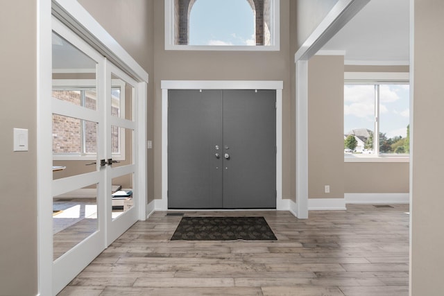 foyer entrance with light hardwood / wood-style flooring and french doors