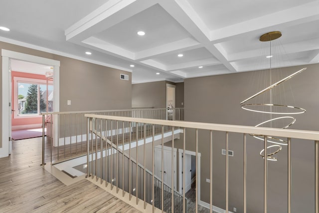 hall featuring beam ceiling, an inviting chandelier, wood-type flooring, and coffered ceiling