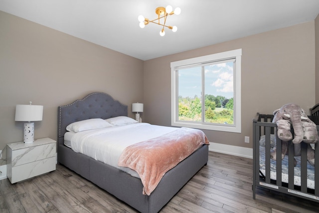 bedroom featuring wood-type flooring and a notable chandelier