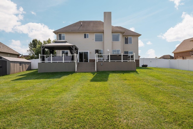 rear view of house featuring a gazebo, a shed, and a lawn