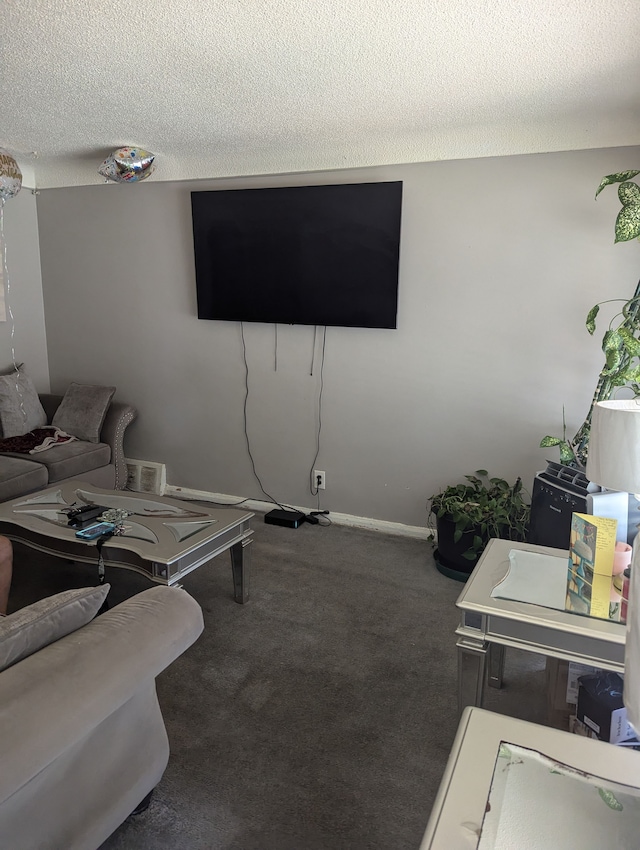 living room with dark carpet and a textured ceiling