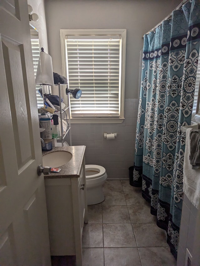 bathroom with tile patterned flooring, vanity, plenty of natural light, and tile walls