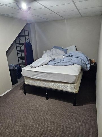 carpeted bedroom featuring a drop ceiling