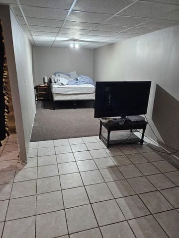 bedroom with a drop ceiling and carpet floors