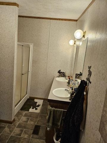 bathroom with vanity and a shower with door