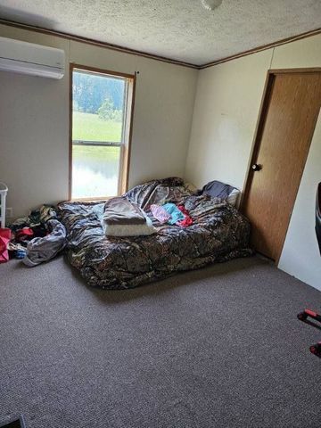 bedroom with carpet, an AC wall unit, and a textured ceiling