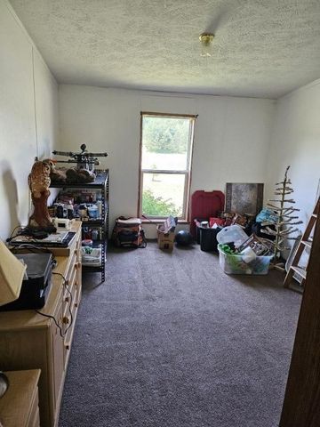 miscellaneous room featuring dark carpet and a textured ceiling