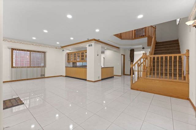 unfurnished living room featuring crown molding and light tile patterned flooring