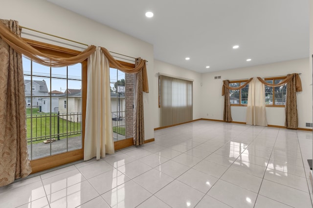 spare room featuring a wealth of natural light and light tile patterned floors