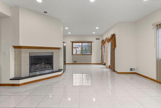 unfurnished living room featuring light tile patterned floors and a tile fireplace