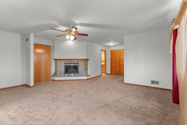 unfurnished living room with a fireplace, carpet, and ceiling fan