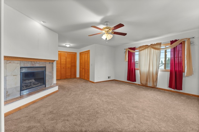 unfurnished living room with carpet, ceiling fan, and a tiled fireplace