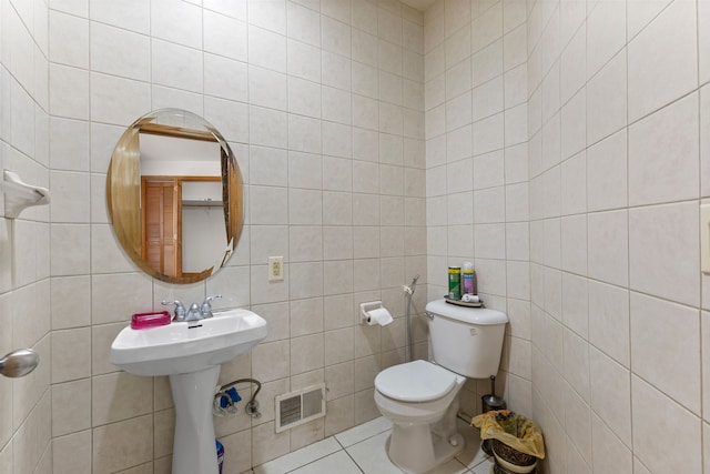 bathroom with tile patterned floors, sink, decorative backsplash, toilet, and tile walls