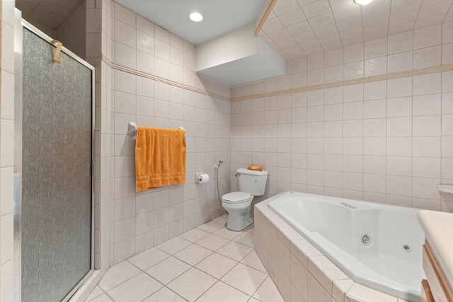 bathroom featuring tile patterned flooring, toilet, tile walls, and plus walk in shower