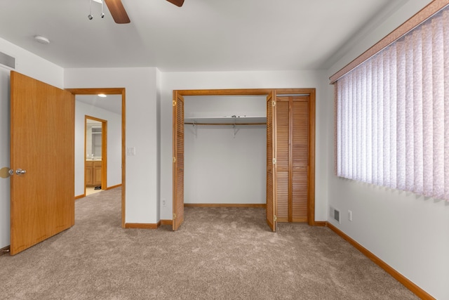 unfurnished bedroom featuring a closet, ceiling fan, and light colored carpet