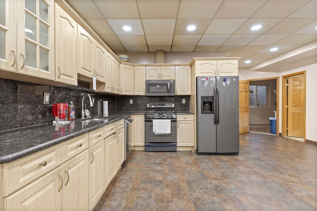 kitchen featuring a paneled ceiling, dark stone counters, sink, tasteful backsplash, and stainless steel appliances