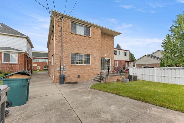 back of house with a lawn and central AC