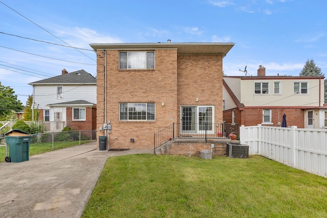 rear view of property with central AC and a lawn