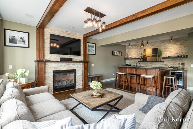 250 Shore Dr, Wayland, MI 49348 - living area with beverage cooler, beamed ceiling, wet bar, wood finished floors, and a stone fireplace