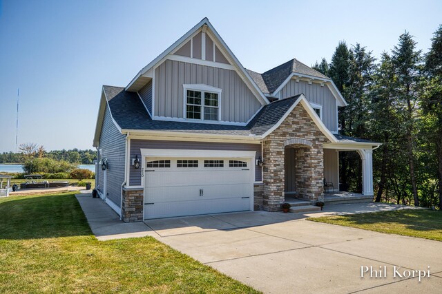 250 Shore Dr, Wayland, MI 49348 - craftsman-style home with board and batten siding, driveway, a front lawn, a garage, and stone siding