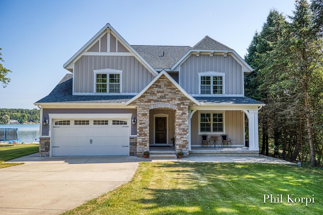 250 Shore Dr, Wayland, MI 49348 - view of front of home with board and batten siding, a shingled roof, concrete driveway, a porch, and a front lawn