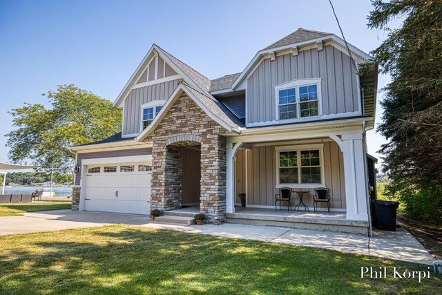250 Shore Dr, Wayland, MI 49348 - view of front of house featuring board and batten siding, covered porch, driveway, and stone siding