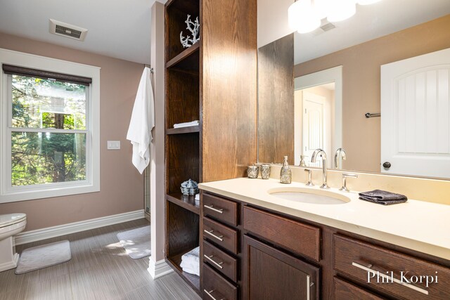 250 Shore Dr, Wayland, MI 49348 - bathroom with toilet, vanity, baseboards, and healthy amount of natural light