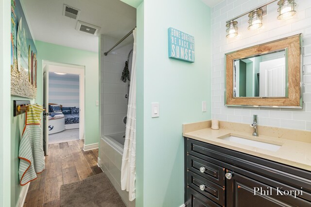 250 Shore Dr, Wayland, MI 49348 - full bath with vanity, wood finished floors, and shower / tub combo