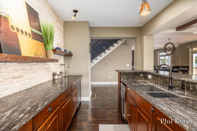 250 Shore Dr, Wayland, MI 49348 - kitchen featuring a sink, open shelves, dark stone counters, baseboards, and dark wood-type flooring