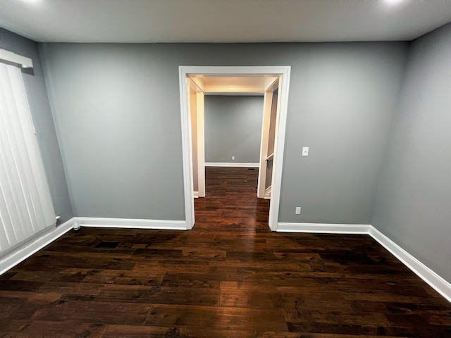 spare room featuring dark wood-type flooring