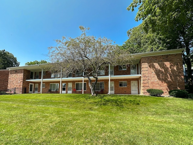 view of front facade with a front yard and brick siding