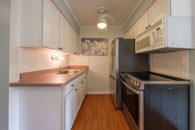 kitchen with stainless steel electric range, white cabinets, sink, ornamental molding, and light hardwood / wood-style floors