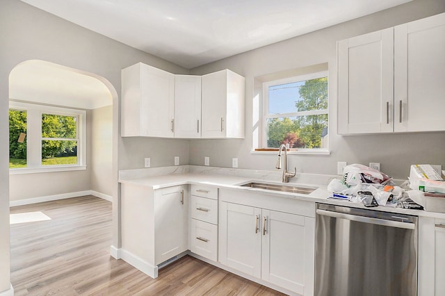 kitchen with dishwasher, white cabinetry, sink, and light hardwood / wood-style flooring