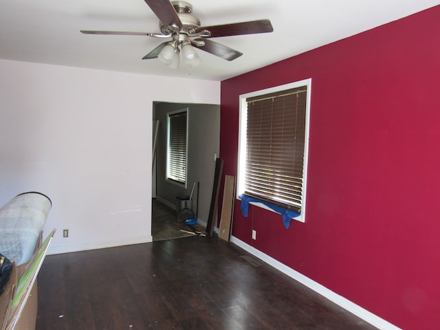 unfurnished room featuring ceiling fan and dark wood-type flooring