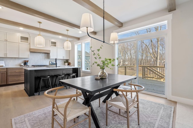 dining space featuring beamed ceiling, recessed lighting, light wood-style floors, and baseboards