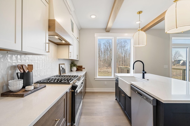 kitchen featuring premium range hood, a sink, stainless steel appliances, beamed ceiling, and backsplash