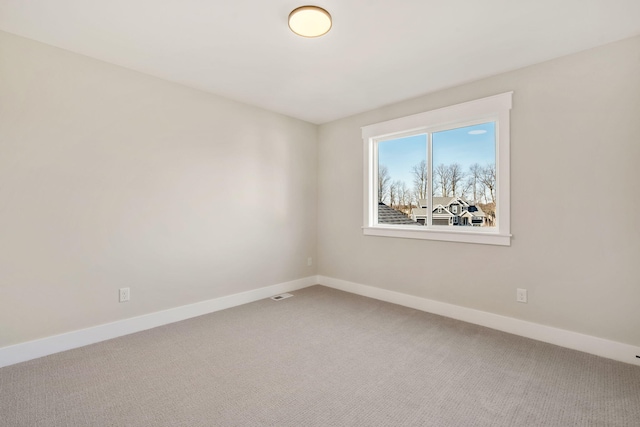 empty room with baseboards, carpet floors, and visible vents