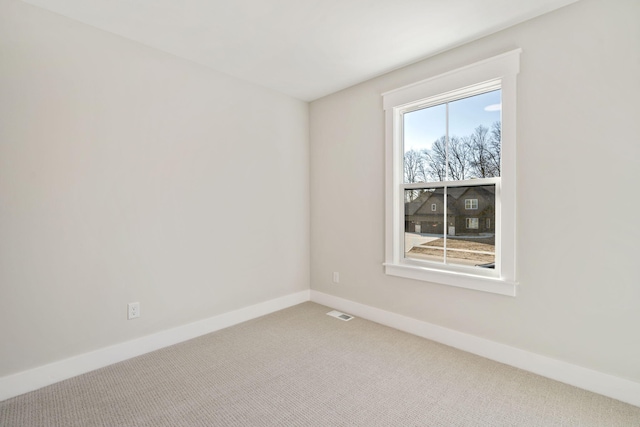 carpeted spare room featuring visible vents and baseboards