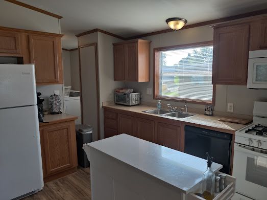 kitchen featuring hardwood / wood-style floors, white appliances, and sink