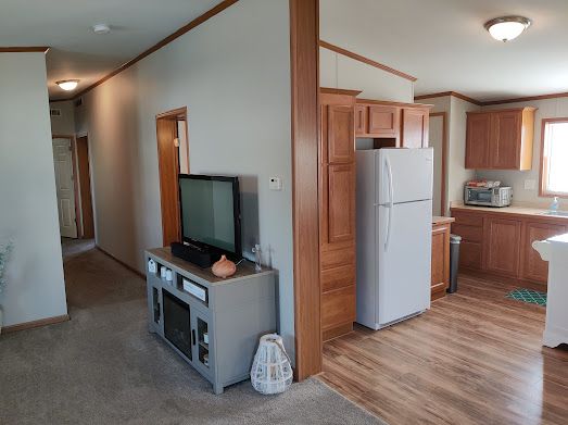 kitchen featuring white fridge, sink, crown molding, and light hardwood / wood-style flooring