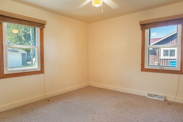 carpeted spare room featuring ceiling fan