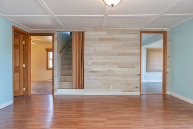 unfurnished room featuring hardwood / wood-style floors, wood walls, and coffered ceiling